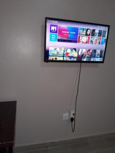a flat screen tv hanging on a wall at Goshen Villa Taita in Voi