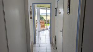 a hallway with a door leading to a room with a view at Appartement T2, RDJ, 2 étoiles, Vue mer panoramique, Côte de Granit Rose in Perros-Guirec