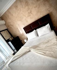 タンジェにあるWellness Homeの白いシーツと枕が付いた大きなベッドのある寝室