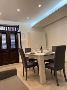 a dining room with a table with chairs and a bottle of wine at Ciuri Ciuri in Castellammare del Golfo