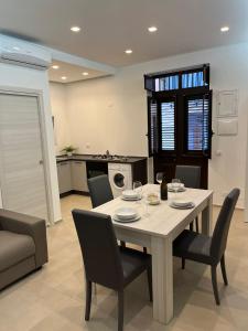 a dining room with a table and chairs and a kitchen at Ciuri Ciuri in Castellammare del Golfo