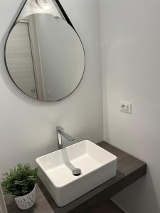 a bathroom with a white sink and a mirror at Ciuri Ciuri in Castellammare del Golfo