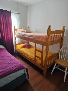 a bedroom with two bunk beds and a chair at Ushuaia de las Nieves B&B in Ushuaia