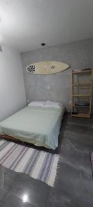 ein Surfbrett, das über einem Bett in einem Zimmer hängt in der Unterkunft Casa de praia com piscina em Governador Celso Ramos in Governador Celso Ramos