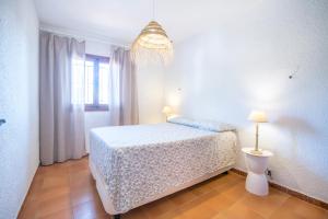 Un dormitorio con una cama y una lámpara. en Chalet Piscina Urbanización De Lujo Cerca Del Mar, en Valencia