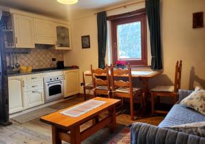 a kitchen with a table and a dining room at La Comba - Les Fleurs in Cerise