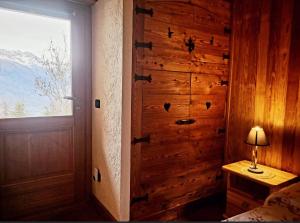 a bedroom with a wooden wall with a door at La Comba - Les Fleurs in Cerise