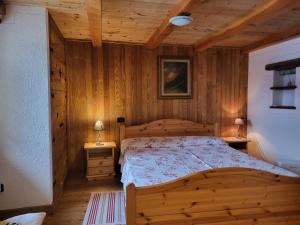 a bedroom with a bed in a wooden room at La Comba - Les Fleurs in Cerise