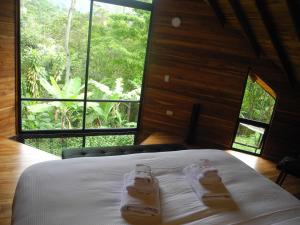 a bedroom with a bed with two slippers on it at Mogambo Ecolodge in Viotá