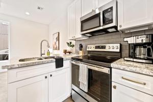Una cocina con gabinetes blancos y un horno de estufa. en Welcoming Town Home Brand New Construction, en Lafayette