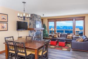 ein Wohnzimmer mit Tisch und Kamin in der Unterkunft Stonegate Resort Unit C105 in Kelowna