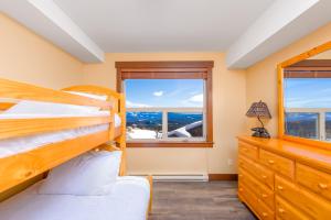 ein Schlafzimmer mit zwei Etagenbetten und einem Fenster in der Unterkunft Stonegate Resort Unit C105 in Kelowna