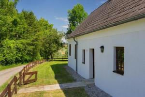 biały budynek z ogrodzeniem obok drogi w obiekcie Das Laffelberghaus w mieście Steinakirchen am Forst