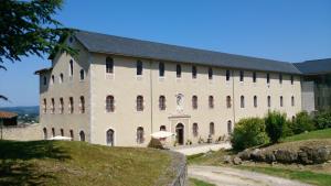 a large building on a hill next to a road at Terres de France - Domaine du Palais in Saint-Lizier