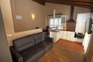 a living room with a couch and a kitchen at Apartamentos Villa Sofía in San Vicente de la Barquera