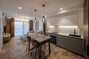 a kitchen with a table and a dining room at King Mindaugas Apartments in Kaunas