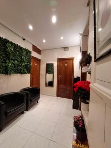 hol z poczekalnią z czarnymi skórzanymi meblami w obiekcie Hostal Villamañez w Madrycie