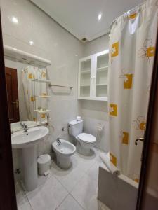 łazienka z 2 toaletami, umywalką i prysznicem w obiekcie Hostal Villamañez w Madrycie