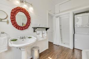 une salle de bain blanche avec un lavabo et un miroir dans l'établissement Tyson House Historic Downtown Cottage, à Cedar Key 35 autres photos