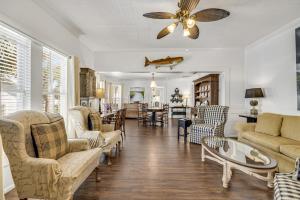 - un salon avec des chaises et un ventilateur de plafond dans l'établissement Tyson House Historic Downtown Cottage, à Cedar Key