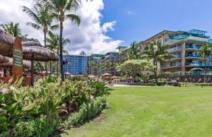 a resort with a park with palm trees and a hotel at Honua Kai Resort And Spa By Maui Resort Rentals in Lahaina