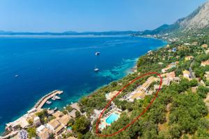 an aerial view of a resort with a boat in the water at Nissaki Sea View Hotel in Corfu