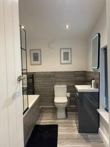a bathroom with a toilet and a tub and a sink at 42 Handbridge Chester in Chester +19 photos