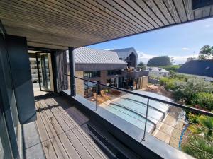 a house with a balcony with a swimming pool at Les Passagers Du Vent in Plouézec