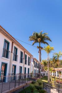 a row of buildings with palm trees in front at Resort Quinta Santa Barbara in Pirenópolis