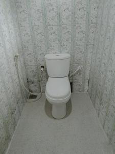 a white toilet in a bathroom with wallpaper at Ocean Pearl Villa - Talalla in Matara