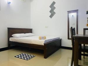 a bedroom with a bed and a table and a mirror at Ocean Pearl Villa - Talalla in Matara