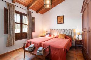 a bedroom with a large bed with a red blanket at Casa Rural La Herradura in Antequera +21 photos