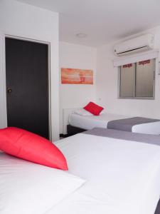 a room with two beds and a door with a red pillow at Depeapan in Cali