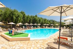 a large swimming pool with chairs and umbrellas at Nissaki Sea View Hotel in Corfu