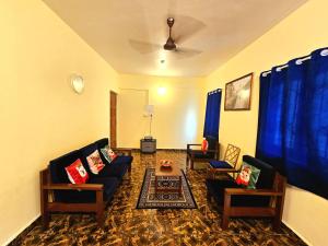 a living room with couches and blue curtains at Casa de Bella in Candolim