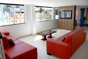 a living room with two red couches and a table at Ancoradouro Hotel - Centro De Porto Seguro in Porto Seguro