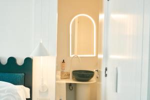 a bathroom with a green bowl on a shelf next to a bed at CALEA Boutique Hotel in Bacoli
