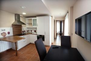a kitchen with a dining room table and a television at Apartamentos Villa Sofía in San Vicente de la Barquera