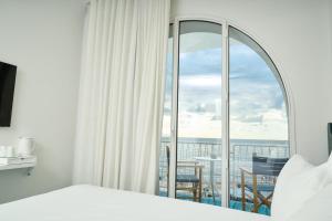 a bedroom with a bed and a window with a view at CALEA Boutique Hotel in Bacoli