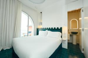 a bedroom with a large white bed and a window at CALEA Boutique Hotel in Bacoli