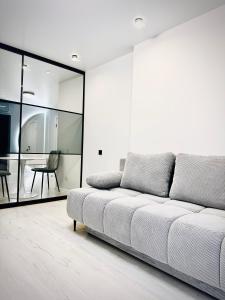 a white couch in a living room with a table at Новобудова вулиця Стрийська 45а FABRIK in Lviv