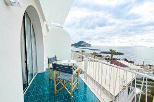 a balcony with a table and chairs looking out at the ocean at CALEA Boutique Hotel in Bacoli