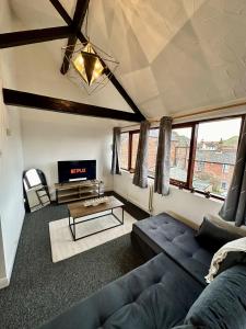 a living room with a blue couch and a tv at Archway House - City Townhouse Sleeps 7 Free Private Driveway Parking For Up To 2 Cars in Norwich