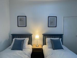 two beds in a bedroom with two pictures on the wall at 42 Handbridge Chester in Chester