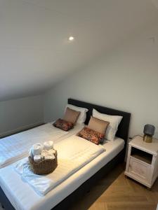 a bed with two pillows and a basket on it at Authentieke 4 persoons cottage vlakbij Valkenburg in Voerendaal