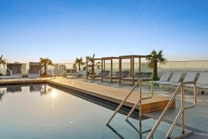 ein Swimmingpool mit Stühlen auf dem Dach eines Gebäudes in der Unterkunft HANS-Y Apartments inklusive Outdoorpool & Bar in Wien