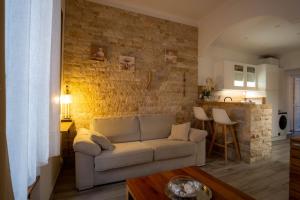 salon z kanapą i ścianą z cegły w obiekcie Appartement très cosy avec cour w Cannes