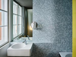 un bagno con lavandino e specchio di Hotel Castell a Zuoz