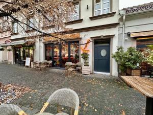 ベオグラードにあるPlavi zec apartman Zemunの建物の前に椅子とテーブルが置かれた店