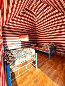 - 2 lits dans une chambre avec un mur rayé dans l'établissement wadi Rum Spirit of Peace Camp, à Wadi Rum